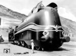 1941 lieferte Henschel mit der Fabriknummer 25.000 die voll verkleidete 19 1001 ab. Dabei wurde der bei elektrischen Lokomotiven bereits bewährte Einzelachsantrieb adaptiert und alle vier Treibachsen einzeln von je einem Dampfmotor angetrieben. Den bislang gebauten Dampflokomotiven waren technische Grenzen gesetzt. Erfahrungsgemäß galten für herkömmliche Dampflokomotivtriebwerke, bei denen die Kraftübertragung durch hin und her gehende Kolben und Treibstangen mit erheblicher Masse erfolgt, Drehzahlen bis 400 min-1, als praktikabel. Oberhalb dieser Drehzahlgrenze ergeben sich massive Probleme mit der Belastung der Treib- und Kuppelzapfen, der Schmierung der unter Dampf gehenden und dem Masseausgleich der hin- und hergehenden Teile. Auch einer Vergrößerung des Treibraddurchmessers zur Erhöhung der Fahrgeschwindigkeit bei gleichbleibender Triebwerksdrehzahl sind technische und konstruktive Grenzen gesetzt. Der größte ausgeführte Treibraddurchmesser lag bei 2300 Millimetern (BR 05 und 61). Bei noch größeren Radsätzen wäre, abgesehen von Stabilitäts- und Masseproblemen, ein entsprechend leistungsfähiger Kessel nicht mehr innerhalb der nutzbaren Fahrzeugumgrenzung unterzubringen. Eine Alternative zum herkömmlichen Dampflokomotivtriebwerk sah man nach dem Vorbild von zur selben Zeit entworfenen elektrischen Lokomotiven im Einzelachsantrieb mit schnelllaufenden Dampfmotoren. Das revolutionäre Antriebskonzept wurde wegen des Zweiten Weltkriegs nicht weiter verfolgt. Bei einigen Erprobungsfahrten im Rahmen von Bremsversuchen des RZA Berlin/Versuchsamt für Bremsen Berlin-Grunewald soll die Lok kurzzeitig eine Höchstgeschwindigkeit von 186 km/h erreicht haben. Die Fa. Henschel "bastelte" diese Collage, um auf die Einzigartigkeit der Lok aufmerksam zu machen. (1941) <i>Foto: Werkfoto</i>