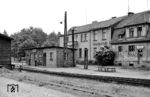 Der kleine Ort Lindenberg in der Prignitz mit rund 300 Einwohnern verfügte vom 15. Oktober 1897 bis zum 31. Mai 1969 über einen Bahnhof, an dem sich zwei Strecken der Prignitzer Kleinbahnen befanden: Die Strecke von Rehfeld nach Perleberg und die in Lindenberg beginnende Strecke nach Bahnhof Glöwen. Am letzten Betriebstag herrschte bereits eine ziemliche Tristesse im Bahnhof Lindenberg. Fast interessanter als der Backsteinbau des Bahnhofs ist das Gebäudeensemble im Hintergrund mit der Gaststätte "Zur Eisenbahn", der Kreisparkasse und der "Staatlichen Hirsch-Apotheke". (31.05.1969) <i>Foto: Helmut Pochadt</i>