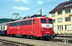 110 236 (Bw Stuttgart) vor einem Schnellzug im Bahnhof Süßen. Die Baureihe 110 musste während ihrer rund 60-jährigen Einsatzzeit vier verschiedene Farbkonzepte über sich ergehen lassen. Nur wenige Lokomotiven trugen dabei jede der vier Lackierungen, insbesondere das orientrote Farbkonzept mit weißem Lätzchen wie bei 110 236, das ab 1987 zur Anwendung kam, wurde von vielen 110ern ausgelassen.  (19.05.1992) <i>Foto: Rolf Hahmann</i>