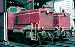 265 008 und 265 011 in ihrem Heimat-Bw Hamburg-Altona. Die Loks verfügten ursprünglich über eine Zugheizung. Der Heizkessel wurde von den Motorabgasen erwärmt. Diese Zugheizanlagen wurden aber zwischen 1964 und 1968 aus den Lokomotiven ausgebaut. Zur Vorwärmung der Maschinenanlage musste diese mit einem Dofa-Koksofen vorgewärmt werden. Zu diesem Zweck dient der Kokshaufen, der bei 265 008 auf dem Umlauf liegt. (08.1968) <i>Foto: Rolf Hahmann</i>