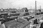 Der Bahnhof Halle (Saale) Gbf war neben dem Bahnhof Dresden-Friedrichstadt einer der bedeutendsten Güterbahnhöfe im Netz der Deutschen Reichsbahn mit einer durchschnittlichen Bergleistung von 2000 Wagen (Nordberg) und 1600 Wagen (Südberg) pro Tag. Von hier aus wurde die Kohle aus den Tagebauen des Bezirkes und Erzeugnisse der Chemiegroßbetriebe Leuna, Buna, Wolfen und Bitterfeld weitertransportiert. An der Berliner Brücke über dem Bahnhof in Höhe des Bw Halle (Saale) G rangieren gleich drei preußische G 8¹. Im Hintergrund ist das Ablaufstellwerk Nordberg "Hg 5" zusehen, rechts das Rangierstellwerk "Hg 4". (07.1956) <i>Foto: Jürgen Hagemann</i>