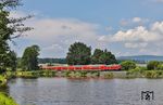 Der Verlauf der Bahnstrecke von Regensburg nach Hof fast ausschließlich in Süd-Nord-Richtung macht es schwierig, um die Mittagszeit überhaupt Fotostellen zu finden, in denen die Züge nicht im Gegenlicht fahren. Das mittägliche Hochlicht ist für eine ansprechende Bildgestaltung auch nicht gerade förderlich. So bleibt letztlich nur der Rechenweiher bei Escheldorf übrig, an dem 218 433 mit dem RE 4865 nach Hof erscheint. (22.06.2026) <i>Foto: Joachim Bügel</i>