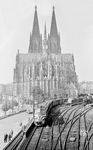 Das Brückengerüst der Hohenzollernbrücke war damals sicherlich nicht frei zugänglich. Dennoch wagte Ernst Winter das Risiko und bescherte uns diesen einmaligen Blick auf den Dom und SNCB 204 006, die mit dem D 84 aus Bruxelles den Kölner Hauptbahnhof verlässt. (28.09.1958) <i>Foto: Ernst Winter</i>