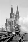 Vor dem Kölner Wahrzeichen startet 01 055 (Bw Hamm P) mit dem D 67 "Riviera-Express" (Ventimiglia - Amsterdam) im Kölner Hauptbahnhof. Auch wenn die Fotostelle nicht zur Nachahmung einladen sollte, der Fotograf war nur bedingt gefährdet, der Zug bog auf der Doppelkreuzungsweiche nach rechts ab. Heute würde eine solche "Untat" direkt eine Streckensperrung und einen Großeinsatz der Polizei auslösen. (28.09.1958) <i>Foto: Ernst Winter</i>