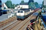 215 079 und 215 090 (beide vom Bw Oberhausen-Osterfeld Süd) passieren mit einem Kohlezug nach Arnsberg den Bahnübergang an der Ardeyer Straße in Langschede und ein gerade noch profilfreies Geländer. (02.09.1989) <i>Foto: Rolf Hahmann</i>