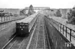 Ein ET 165 der Wannseebahn nach Frohnau bei der südlichen Tunneleinfahrt in den Nordsüdtunnel der Berliner S-Bahn.  Über dem Zug ist der historische Görlitzer Steg (auch als Görlitzer Fußgängersteg oder Anhalter Steg bekannt) zu sehen. Diese markante Gitterträger-Konstruktion war keine provisorische Behelfsbrücke im klassischen Sinne, sondern eine dauerhafte Fußgängerbrücke mit einer besonderen Geschichte. Der Steg überspannte das tiefgelegene Gleisbett der S-Bahn-Strecken südlich des Anhalter Bahnhofs nahe dem heutigen Deutschen Technikmuseum. Er verband das Großadmiral-von-Koester-Ufer (heute Schöneberger Ufer) auf direktem Weg mit der dahinterliegenden Schöneberger Wiese und dem Tempelhofer Vorfeld. Die Brücke trug den Namen "Görlitzer Steg", weil sie ursprünglich im Jahr 1910 für den Görlitzer Bahnhof in Kreuzberg gebaut worden war. Im Zuge von Bahnhofsumbauten wurde sie dort demontiert und Ende der 1930er Jahre an genau diesen Standort an der S-Bahn-Einfahrt zum Nord-Süd-Tunnel versetzt. Nach dem Zweiten Weltkrieg und der Stilllegung des Anhalter Bahnhofs verloren die Wegeverbindungen an Bedeutung. Die Brücke wurde später demontiert. Heute befindet sich in unmittelbarer Nähe eine moderne, namentlich angelehnte Fußgänger- und Radfahrerbrücke über den Landwehrkanal, der Anhalter Steg. (04.1968) <i>Foto: Jürgen Hagemann</i>