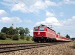 ÖBB 1044.60 mit einem langen Regionalzug zwischen Abzweig Hufschlag und Traunstein. Links sieht man das Georgikircherl hervorspitzen. (05.1981) <i>Foto: Ulrich Hesse</i>