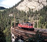 Üblicherweise herrschte in Österreich seit der k.k. Monarchie ein Mix von Rechts- und Linksverkehr auf den Eisenbahnstrecken. Damals hatte praktisch jede Bahngesellschaft ihre eigene Fahrordnungen. Erst 1938 kam mit dem Anschluss ans Deutsche Reich der Rechtsverkehr mit der Reichbahn von Westen her ins österreichische Netz, wurde aber wegen der technischen Gegebenheiten nur bei Neu- und Ausbauten angewandt, weshalb auch nach dem Krieg der Linksfahrbetrieb im Osten und Süden Österreichs noch immer vorhanden war. Bis 2012 stellte die ÖBB den Bahnverkehr großflächig auf Rechtsverkehr um. Als letzte Relikte des Linksverkehrs blieben noch zwei Strecken: Mürzzuschlag-Werndorf und die Franz-Josephs-Bahn Wien-Tulln. Noch im Linksverkehr erklimmen ÖBB 1042.585 vor einer 1044 den Semmering auf dem Krausel-Klause-Viadukt nahe Breitenstein. (13.09.1990) <i>Foto: Ulrich Hesse</i>