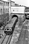 Ein ET 165 auf der Zuggruppe 3 nach Lichtenrade fährt aus dem S-Bahnhof Gesundbrunnen (Nord-Süd-Bahn), Bahnsteig C. Am Gebäude sieht man unten die verklinkerte alte Bausubstanz, darüber den nach dem Krieg vereinfacht wieder aufgemauerten Gebäudeteil mit der weiterlaufenden überdachten Fußgängerbrücke.  (04.1965) <i>Foto: Jürgen Hagemann</i>