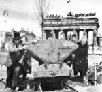 Nach dem Krieg lagen viele deutsche Städte in Trümmern. Auch Berlin hatte es hart getroffen. Mehr als 350 Luftangriffe seit 1940 hatten gut die Hälfte des Wohnraumbestandes zerstört. Schon im Juni 1945 wurden in Berlin alle Arbeitsfähigen zwischen 15 und 50 Jahren zur Trümmerbeseitigung verpflichtet. Wer im erwerbsfähigen Alter nicht arbeitete, bekam keine Lebensmittelkarten. Schon bald verrichteten größtenteils die Frauen auf den Schutthalden schwerste Knochenarbeit mit primitivem Werkzeug oder mit bloßen Händen, weil die Männer noch in Kriegsgefangenschaft waren. Im Amtsdeutsch hießen sie 'Bauhilfsarbeiterinnen', den Namen 'Trümmerfrauen' gaben ihnen die Amerikaner – rubble-women. Bis 1949 beseitigten die Trümmerfrauen in Berlin fünf Millionen Tonnen Schutt. Das Bild zeigt Aufräumarbeiten am Brandenburger Tor, das zum 1. Mai 1946 mit sowjetischen Flaggen gespickt ist. (05.05.1946) <i>Foto: Pressefoto ACME</i>
