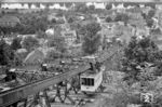 Trotz erheblicher Anstrengungen konnte sich das Schwebebahn-System letztlich nicht gegen die Konkurrenz der Standhochbahnen etablieren. Es wurde, außer in Wuppertal, nur noch bei der Schwebebahn Dresden (Foto) realisiert. Die ebenfalls nach dem System von Eugen Langen errichtete 274 m lange Bahn wurde am 6. Mai 1901 eröffnet und wird oft als „kleine Schwester“ der Wuppertaler Schwebebahn bezeichnet. Im Gegensatz zur Wuppertaler Schwebebahn haben die Dresdner Fahrzeuge jedoch keinen eigenen Antrieb, sondern werden ähnlich wie bei einer Standseilbahn durch ein 390 Meter langes Zugseil bewegt. Der Blick geht hier von der Endstation Oberloschwitz (ehemals Rochwitzer Höhe) auf 198 m Höhe auf einen talfahrenden Wagen zur Talstation Körnerplatz auf 124 m Höhe im Stadtteil Loschwitz. (19.06.1966) <i>Foto: Basil Roberts</i>