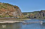 Eine 193 der SBB Cargo trifft am Kammereck-Tunnel bei St. Goar auf das unter rumänischer Flagge fahrende Frachtschiff "DAMIMEX 2". Unverkennbar wurde die Ladung des Schiffes stark reduziert, um überhaupt noch auf dem Rhein fahren zu können. Der Pegel Kaub lag an diesem Tag bei 16 cm. Links sind die Untiefen "Geisenrücken und Heringsnas" zu erkennen. (08.08.2026) <i>Foto: Zeno Pillmann</i>