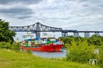 Über dem Nord-Ostsee-Kanal begegnet RE 11171 dem Containerschiff "BF CARP". Das 2009 gebaute Schiff fährt unter der Billigflagge von Antigua & Barbuda in der Karibik.  In dem Land mit 100.000 Einwohnern waren 2025 allein 953 Schiffe registriert.  (31.07.2026) <i>Foto: Thorsten Eichhorn</i>