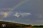 Regenbogen - die Vierte: Für einen Sekundenbruchteil brach die Sonne am Hindenburgdamm durch die Wolkendecke und erzeugte ein surreales Licht, als der AS 1448 mit der führenden 218 497 aus einem dichten Regenschleier hervortrat. (22.08.2026) <i>Foto: Joachim Bügel</i>