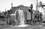 044 216 (Bw Gelsenkirchen-Bismarck) beim Wassernehmen im Bw Wanne-Eickel. Das Überlaufen war nicht bestellt, zumal es die Dosierung durcheinanderbrachte und daher eher verpönt war. Hier hatten sich die Kollegen einfach nur "verquatscht" und schon war's passiert.  (23.05.1972) <i>Foto: Wolfgang Bügel</i>