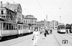 Straßenbahnen am Wilhelmplatz (heute Konrad-Adenauer-Platz) vor dem Düsseldorfer Hauptbahnhof. Während des Zweiten Weltkriegs wurden durch den Luftangriff vom 12. Juni 1943 viele Gebäude um dem Platz beschädigt und zerstört, die auch vier Jahre nach dem Krieg nur notdürftig repariert waren. Alle Häuser wurden später abgerissen und durch Neubauten ersetzt. (08.1949) <i>Foto: Ernst Winter</i>
