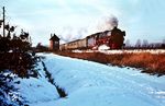 012 076 stürmt mit dem E 1776 (Westerland/Sylt - Hamburg-Altona) an einem Schrankenposten südlich von Pinneberg vorbei. (02.1968) <i>Foto: Jürgen Hagemann</i>
