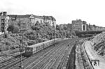 Ein ET 169 der Bauart 'Bernau', angeglichen an die Bauart 'Stadtbahn' auf der Ringbahnstrecke am S-Bahnhof Westend. Die Zuggruppe C fuhr von der Warschauer Straße über den Nordring nach Berlin-Gartenfeld oder Berlin-Halensee. Der Fotograf steht auf der Knobelsdorfbrücke und blickt nach Süden auf die Kurfürstendamm-Brücke. Links am Rand ist das Ende der südlichen Kehranlage des Bahnhofs Westend zu sehen, rechts beginnen die Bauarbeiten für die Stadtautobahn A 100. (07.1960) <i>Foto: Jürgen Hagemann</i>
