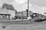 Eine unerkannt gebliebene Kriegslokomotive der BR 52 mit Steifrahmentender in Berlin-Tegel Hafen vor dem Lokschuppen der Industriebahn. Der Fotograf steht auf der Ladestraße des Bahnhofs, dem westlichen Endpunkt der 1908 eröffneteten 23 km langen Industriebahn Tegel-Friedrichsfelde (ITF). Am 1. Juli 1950 wurde die private Anschlussbahn mit dem Lokbahnhof Berlin-Tegel Hafen von der DR übernommen. Die Strecke führte durch die heutigen Berliner Bezirke Reinickendorf, Pankow und Lichtenberg nach Marzahn-Hellersdorf und verband mehrere Industrieunternehmen mit dem Güterverkehrsnetz der Reichsbahn. Seit den 1970er Jahren wurde die Industriebahn schrittweise stillgelegt, da sie Straßenbaumaßnahmen im Weg stand. Das markante Gebäude im Hintergrund ist die Tegeler Humboldtmühle, ein Anschließer der ersten Stunde. Rechts vom Lokschuppen steht ein Getreidesilo, der noch heute existiert.  (06.1963) <i>Foto: Jürgen Hagemann</i>