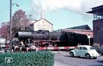 50 522 (Bw Radolfzell) verlässt mit einem Güterzug den Bahnhof Friedrichshafen. Am Bahnübergang der Olgastraße steht das Stellwerk 3, ein E-43-Stellwerk aus dem Jahr 1953. Obwohl das Stellwerk am 27.11.2004 außer Betrieb ging, war das Gebäude 2026 noch vorhanden. (05.1964) <i>Foto: Rolf Hahmann</i>