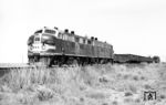 Die EMD F7 ist eine dieselelektrische Lokomotive des amerikanischen Herstellers General Motors Electro-Motive Division (EMD). Sie stellt mit 3849 Exemplaren die zahlenmäßig stärkste Serienlok der EMD dar. Die EMD F7 hatte einen selbsttragenden Lokkasten mit nur einem Führerstand. Dahinter lag der Maschinenraum mit dem Traktionsgenerator, welcher den Gleichstrom für die Fahrmotoren lieferte, und dem Dieselmotor EMD 567B. Die Typbezeichnung EMD 567 bedeutet, dass der Motor einen Hubraum von 567 Kubikzoll (ca. 9,3 Liter) pro Zylinder hatte. In den Fahrzeugen kamen Motoren mit 16 Zylindern zur Anwendung. Die Lok leistete 1.500 PS und konnte je nach Getriebeübersetzung bis zu 160 km/h erreichen. Mit einem kurzen Güterzug ist No. 267 der Atchison, Topeka and Santa Fe Railway, kurz Santa Fe, bei Portales im Osten des US-Bundesstaates New Mexico unterwegs. (08.10.1971) <i>Foto: Jörg Schulze</i>