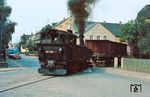 99 1608 fährt mit einem Rollwagenzug aus Glossen über die heutige Dr.-Friedrichs-Straße in Mügeln ein.  (21.09.1981) <i>Foto: Rolf Hahmann</i>