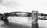 Die Hubbrücke Magdeburg an der Strecke Magdeburg-Buckau - Elbbahnhof - Brückfeld - Biederitz überspannt die Elbe bei Stromkilometer 325,47. Sie ist mit Baujahr 1895 eine der ältesten und mit 220m und 90m Stützweite eine der größten Hubbrücken Deutschlands. Zwischen 1933 und 1934 erfolgte der letzte Umbau, dessen Zustand auf dem Foto dokumentiert ist. Am 16. April 1945 wurde das Bauwerk von deutschen Truppen gesprengt, 1946 war es wiederhergestellt. Aufgrund der defekten Hubvorrichtung wurde das Bauwerk im Juni 2001 in angehobenen Zustand arretiert. (1935) <i>Foto: RVM</i>