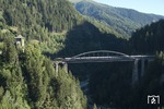 ÖBB 1020 042, die im Grün der Umgebung fast verschwindet, mit einem Sonderzug auf der 230m langen Brücke über die Trisannaschlucht bei Landeck auf der Arlbergbahn. Links schaut der Turm von Schloß Wiesberg aus dem Wald. (18.08.2012) <i>Foto: Joachim Schmidt</i>