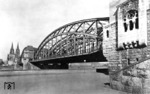Die von 1907 bis 1911 errichtete Hohenzollernbrücke über den Rhein bestand ursprünglich aus zwei Eisenbahn- und einer Straßenbrücke (Foto). Sie verbindet Köln-Deutz mit dem Hauptbahnhof. Nach 1945 erfolgte der Wiederaufbau der kriegszerstörten Brücke mit nur noch zwei Eisenbahnbrücken, die später um eine dritte (S-Bahn) ergänzt wurde. Als Ersatz für die entfallene Straßenbrücke wurden an die äußeren Eisenbahnbrücken Geh- und Radwege angesetzt.  (1932) <i>Foto: RVM</i>