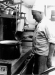 Der Koch im Stellwerksbauzug 4 der RBD Hannover bei der Arbeit. Der Inhalt des Kochtopfs war nicht zu identifizieren. (1942) <i>Foto: RVM (Bandelow)</i>