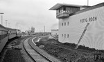 Kurz vor der Eröffnung des neuen Fährbahnhofs Puttgarden wird noch letzte Hand an die Beschriftung des Stellwerks gelegt. Blick aus einem der Meßzüge bei den Hochtastfahrten mit V 200 111. (09.04.1963) <i>Foto: Walter Hollnagel</i>