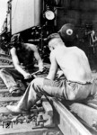 Unerschrocken wird auch bei Vorbeifahrt einer Lok am Herzstück der Weiche weitergearbeitet, in einer Arbeitskleidung, die heute keinen Schutzvorschriften mehr standhalten würde. (1934) <i>Foto: RVM</i>