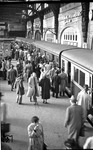 Geschäftiges Treiben auf dem S-Bahn-Bahnsteig im Hamburger Hauptbahnhof. An der Wand sind noch die montierten Ausleger mit Fahrleitung (!) der bereits 1955 eingestellten Oberleitungs-S-Bahn montiert. (20.07.1964) <i>Foto: Walter Hollnagel</i>
