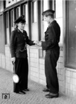 Die Aufsichtsbeamtin des S-Bahnhofs Zepernick (Kr Niederbarnim) im Gespräch mit einem Soldaten der Panzertruppe (Panzerschütze, einfacher Dienstrang). (1942) <i>Foto: RVM (Ittenbach)</i>