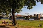 Die Rheinwiesen an der Kölner Südbrücke sind bei schönem Wetter beliebtes Ausflugsziel zum Spazierengehen, Radfahren, Grillen oder Relaxen. Am lauen Sommerabend des 16. August 2013 passiert 152 103 mit EZ 45723 nach Gremberg die Szenerie. (16.08.2013) <i>Foto: Joachim Bügel</i>