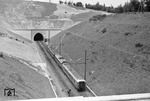 An der Strecke Köln – Aachen befand sich bis 1964/65 der Nirmer Tunnel. Für die Streckenelektrifizierung und die schon seinerzeit geplanten Schnellfahrten musste das Lichtraumprofil erweitert werden. Da der Tunnel bereits 1841 fertiggestellt wurde, war das Gemäuer altersbedingt marode. Zudem hatte der Nirmer Tunnel im Bereich des Ostportals im Zweiten Weltkrieg schwere Schäden davongetragen. Im Gegensatz zu dem zwischen den Bahnhöfen Großkönigsdorf und Horrem gelegenen Königsdorfer Tunnel, der vollständig aufgeschlitzt und in einen Einschnitt umgewandelt wurde, entschied sich die DB im Fall des 727 m langen Nirmer Tunnels für ein teilweises Aufschlitzen. Es sollte ein 125 m langer Eilendorfer Tunnel, ein 185 m langer Einschnitt und ein 125 m langer Nirmer Tunnel neu gebaut werden. Bei der Maßnahme mussten nach anfänglichen Schätzungen 870.000 m³ Erdmasse abtransportiert werden.Die DB begann im Juli 1964 bei Fortsetzung eines eingleisigen Fahrbetriebes mit den Arbeiten. Beim Aufschlitzen des Tunnels wurde Fließsand angetroffen, der die gesamte Baumaßnahme erschweren sollte. Besonders an der südlichen Böschung des Mittelabschnitts kam es von Anfang an zu Rutschungen.Am 28. Februar 1966 wurde der Neubau dieses Tunnelabschnittes vollendet. Der zweigleisige Regelbetrieb wurde am 4. April 1966 wieder aufgenommen. Am 23. Mai 1966 begann der planmäßige elektrische Zugbetrieb zwischen Köln und Aachen (mit Dank an R. Keller (Text). Das Bild zeigt 110 300 bei Versuchsfahrten am Nirmer Tunnel. (04.1966) <i>Foto: Fischer</i>