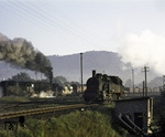 Während 94 1175 sich an den ihren nächsten Zug im Bahnhof Suhl begibt, schiebt eine ölgefeuerte 44 einen Güterzug die Rampe nach Zella-Mehlis hinauf. (20.09.1969) <i>Foto: Robin Fell</i>