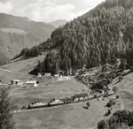 Im Sommer 1980 herrschte auf der Brennerbahn noch eine sehenswerte Typenvielfalt. Neben den ÖBB-Reihen 1110, 1010, 1044, 2043 (im Korridor nach Lienz), 1145, 1245 und 1670 sowie den DB-Baureihen 111, 150, 151 und 110 kamen auch deutsche und österreichische E 94er vorbei. Hier ziehen zwei orangefarbene 1020er einen Güterzug hinter dem Jodoktunnel in der großen St. Jodoker Kurve bergwärts. Die RoLa steckte damals noch in den Kinderschuhen. Die italienischen Spitzdachgüterwagen sind heute längst Geschichte.  (23.08.1980) <i>Foto: Ludger Kenning</i>