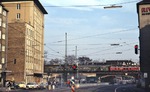 Eine unbekannte 215 überquert vor einem Nahverkehrszug nach Jünkerath die Venloer Straße am Bahnhof Köln-West. (10.04.1979) <i>Foto: Peter Schiffer</i>