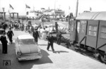 "Auto im Reisezug" in Großenbrode Kai. Zur Beförderung kamen MPw 4yg(e)-Wagen (hier: 113 802 Mü) zum Einsatz. Vorne wartet ein Ford Taunus aus Flensburg, im Hintergrund das Fährschiff "Theodor Heuss". (1959) <i>Foto: Walter Hollnagel</i>