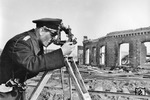 Nach der Zerstörung der Bahnanlagen mussten die Vermesser - hier ein techn. Reichsbahninspektor (tRI) - ran, die für den Wiederaufbau wie am Lokschuppen des Bw Poltawa Ost, die notwendige Gleisgeometrien ausmessen mussten. (1943) <i>Foto: Walter Hollnagel</i>