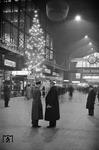 Plausch zwischen dem Auskunftsbeamten und einem Wehrmachtssoldaten in der weihnachtlich geschmückten Halle des Hamburger Hauptbahnhofs. Es war wohl das letzte "Lichterfest" im Hauptbahnhof. Für die nächsten 5 Jahre gingen nachts erst einmal alle Lichter aus. (12.1939) <i>Foto: Walter Hollnagel</i>