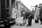 Hilfestellung durch einen freundlichen Zugschaffner im Bahnhof Rheine. Wie immer viele Zuschauer und wenig Helfer. Bei dem Wagen handelt es sich um einen bereits stark "vereinfachten" Länderbahn-D-Zug-Wagen. Die Lüftungsklappen über den Fenstern wurden alle stillgelegt und verblecht.  (16.05.1952) <i>Foto: Quebe</i>