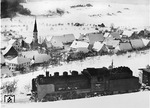 Im verschneiten Schwarzwald ist 24 030 (Bw Freudenstadt) auf der Strecke Freudenstadt - Eutingen (Württ) oberhalb der Ortslage Bittelbrunn unterwegs. Die Häuser werden von der Dorfkirche St. Georg überragt. (1940) <i>Foto: RVM (Ulmer)</i>