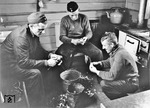 Auch das gehörte zum Dienst: Im Küchenwagen eines Ausbesserungszuges üben sich die Eisenbahner eher lustlos im gemeinschaftlichen Kartoffeln schälen. (1943) <i>Foto: Walter Hollnagel</i>