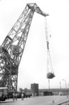 Das Umladen einer Turbine von einem Tiefladewagen aufs Schiff erfordert den Einsatz eines 100 t-Krans im Hamburger Hafen. (11.06.1958) <i>Foto: Walter Hollnagel</i>
