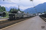 Bereits bei der Planung der Baureihe E 94 war Österreich an das Dritte Reich angeschlossen. Deshalb wurde ein Einsatz im ehemals österreichischen Bahnnetz auf den Alpenrampen Arlbergbahn, Karwendelbahn, Karawankenbahn, Tauernbahn und Brennerbahn als Zug-, Vorspann- und Schiebelokomotive explizit vorgesehen. Nach Kriegsende befanden sich 44 Loks der Baureihe E 94 in Österreich. 1953/54 stellten die Österreichischen Bundesbahnen (ÖBB) aus Teilen der nicht fertiggestellten E 94 146 bis 148 drei weitere Lokomotiven her, die anhand der symmetrischen Seitenwandaufteilung, der Stromabnehmerbauart Typ IV und der großen Laternen leicht von den ehemaligen E 94 zu unterscheiden waren. Zu den Nachbauten gehörte ÖBB 1020.45, die hier einer unbekannten 1110 Vorspann vor einem Schnellzug auf der Giselabahn in Kitzbühel leistet. Da die Reihenbezeichnung bei der ÖBB im Jahr 1954 von E 94 in 1020 geändert wurde, wurde die nachgebaute 1020.45 direkt mit der neuen ÖBB-Baureihenbezeichnung abgeliefert. (1973) <i>Foto: Robin Fell</i>