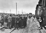 Zwangsarbeiter aus der Ukraine vor der Abfahrt nach Deutschland. Was den Menschenauflauf mit Diskussion der Reichsbahner verursacht haben könnte, ist nicht zu deuten. (1943) <i>Foto: Walter Hollnagel</i>