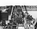 Im Frühjahr 1945 sprengten deutsche Truppen bei ihrem Rückzug die Steinheimer Mainbrücke. Über eine Behelfskonstruktion konnte zunächst der Fußgängerverkehr 1945 wieder ermöglicht und der Eisenbahnverkehr am 2. August 1947 – zunächst eingleisig – wiederaufgenommen werden, bevor der endgültige Wiederaufbau erfolgte.  (1945) <i>Foto: Pressefoto ACME</i>