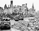 Auch wenn es kein Eisenbahnfoto ist, verdeutlicht dies den Zustand Deutschlands am Ende des Zweiten Weltkriegs. US-Sherman Panzer des 771 Panzerbataillion fahren zur Unterstützung der 17. Luftlandedivision durch das zerstörte Münster. (1945) <i>Foto: Pressefoto ACME</i>